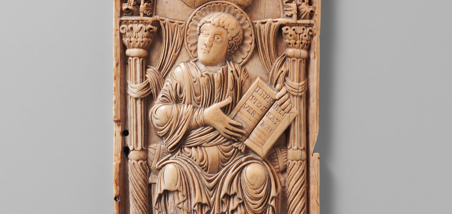 Ivory plaque with Saint John the Evangelist seated, accompanied by his symbol, the eagle, displays the opening text of his gospel. 