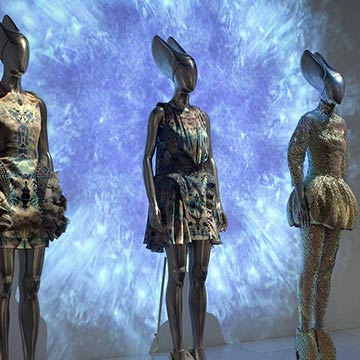  Mannequins lined up on a display wearing futuristic, metallic outfits