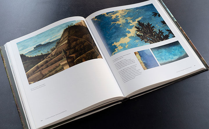 Opened book on a black table shows several details of Giovanni Bellini’s Saint Francis in the Desert, a painting from the Frick Collection. The chapter in the book was written by Charlotte Hale, a Conservator in the Paintings Conservation department.