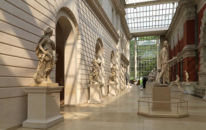 A large, long, sunlit interior courtyard for large European sculptures