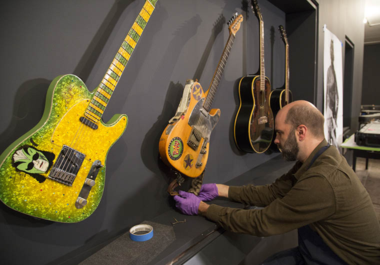 A conservator mounting a guitar on a custom mount