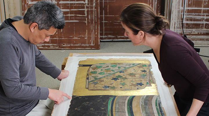 Two conservators looking at a work on paper
