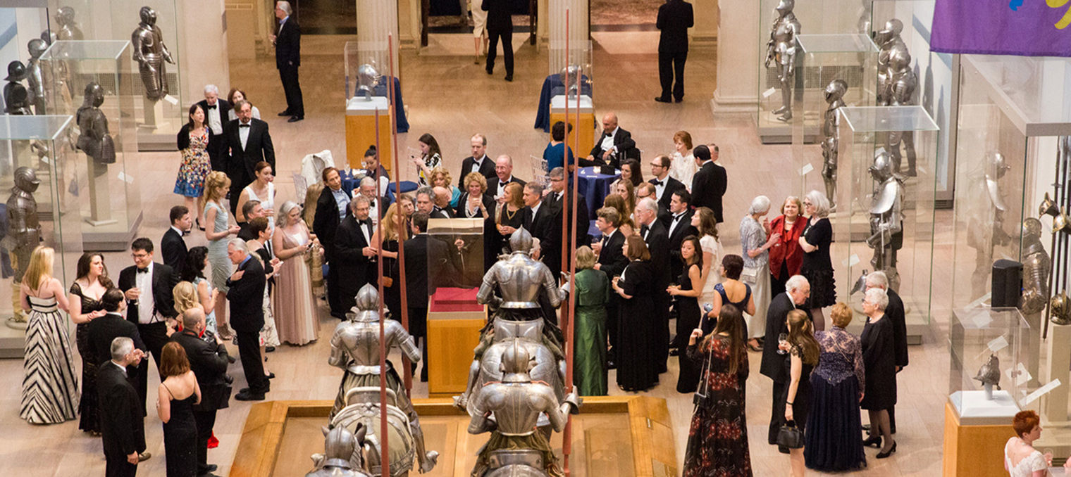 Party goers socializing in the Arms and Armor galleries.