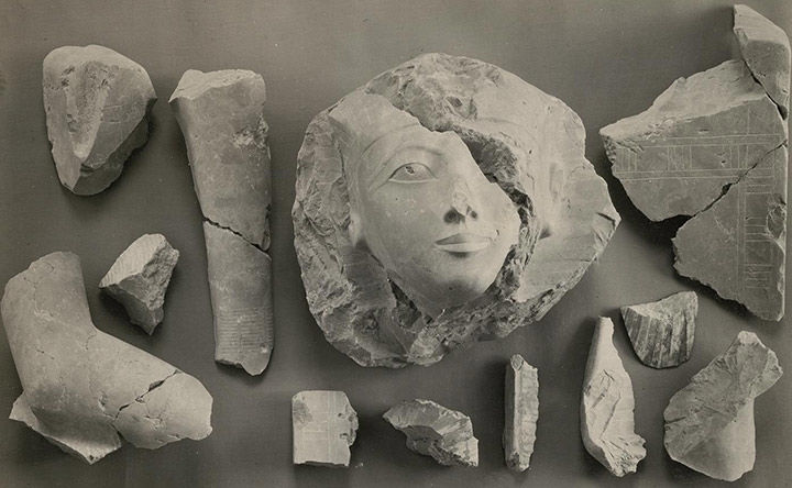 Black-and-white photo of various pieces of a statue of Hatshepsut disassembled