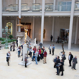 A group of people crowds around a tall sculpture
