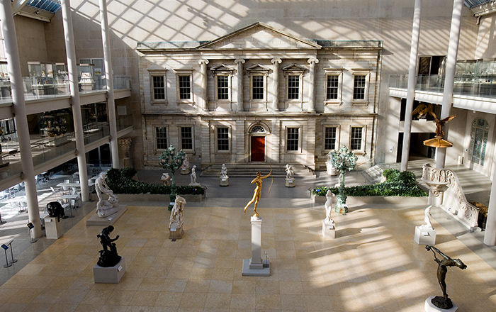 Several sculptures are exhibited throughout a large, open, indoor court