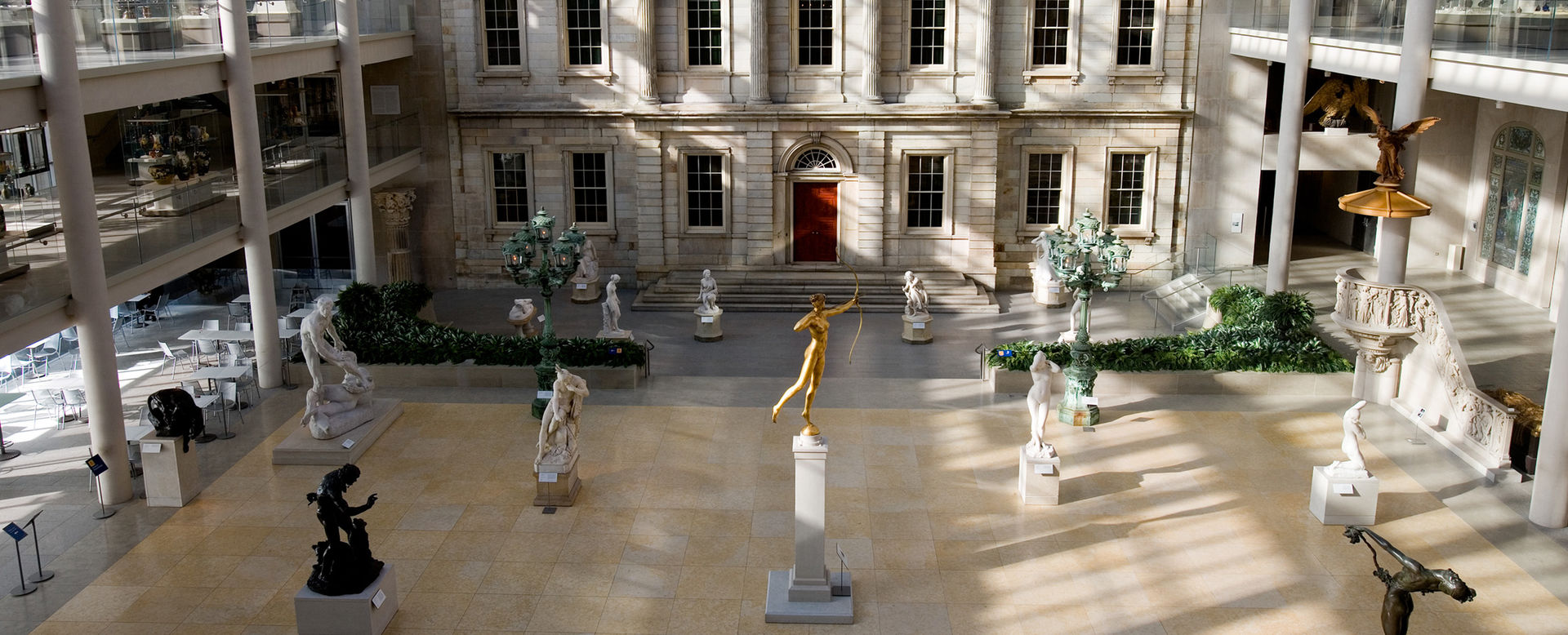 Several sculptures are exhibited throughout a large, open, indoor court